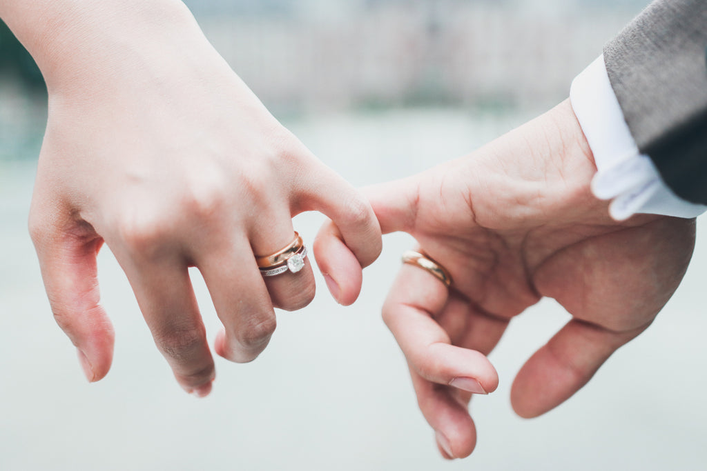 Unrecognizable newlywed couple doing a pinky promise