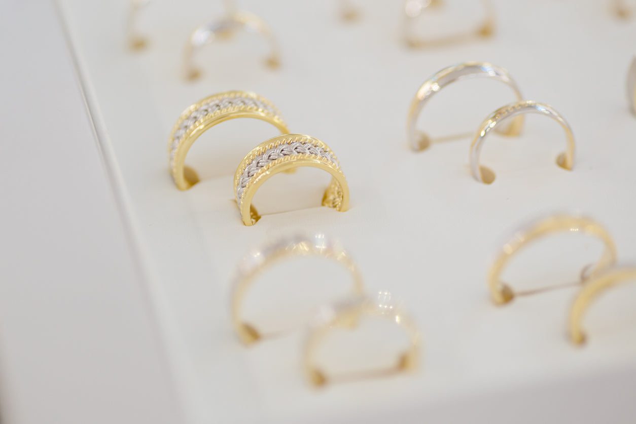 Silver and gold rings on the display in jewelry store