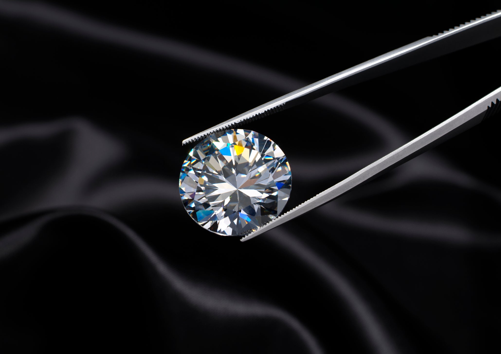 Tweezers holding a shimmering diamond