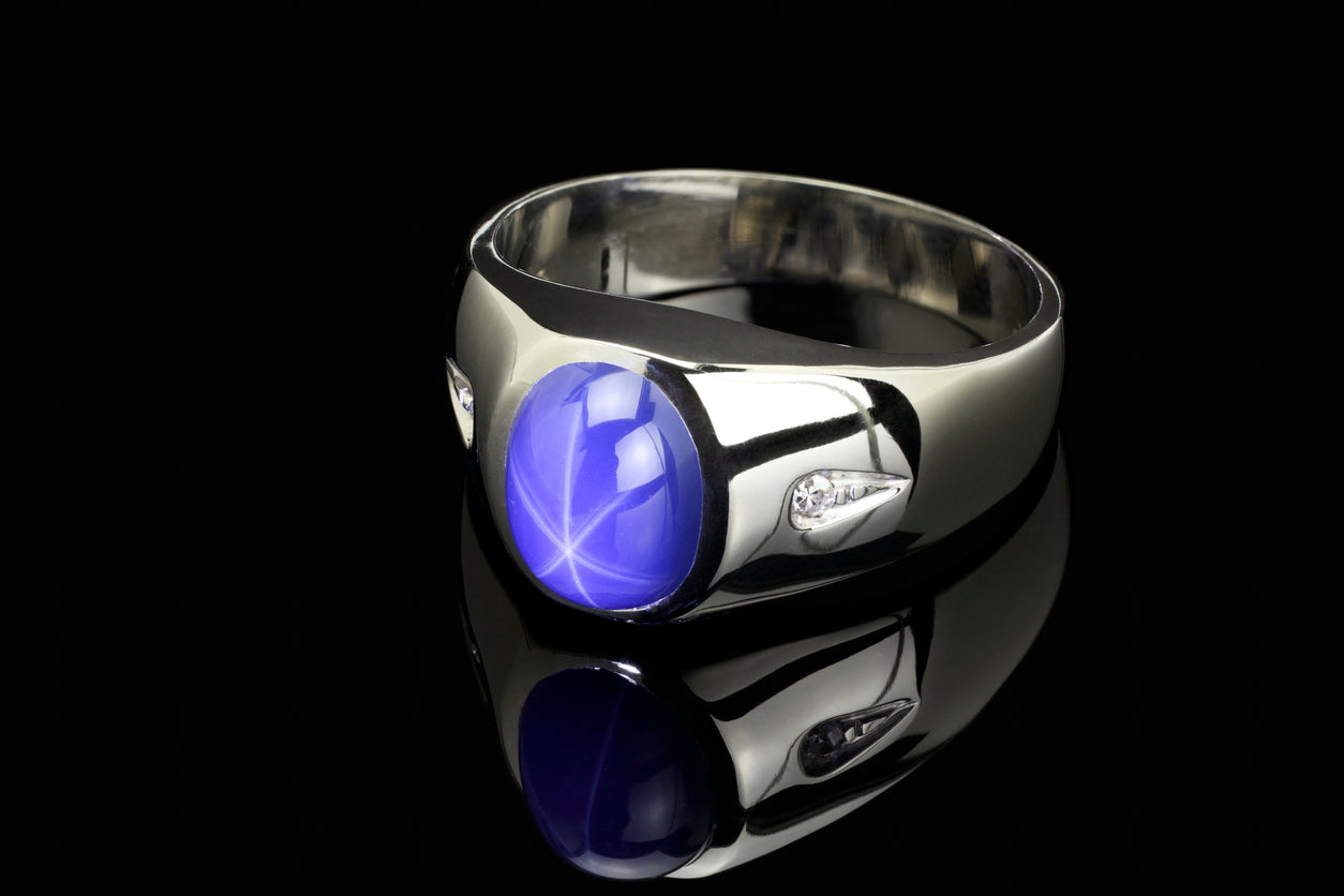 Blue Star Sapphire with Diamond Platinum Ring on Black Background.